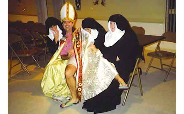 Fr. Lubric cheerfully sitting on some nuns laps